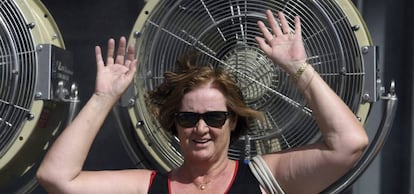 Una mujer se coloca ante un ventilador para refrescarse.