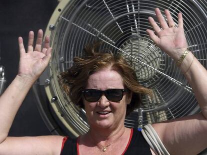 Una mujer se coloca ante un ventilador para refrescarse.