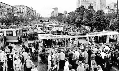 Cidadãos em frente a uma barricada de ônibus em Moscou, cenário onde, na noite anterior, haviam ocorrido confrontos entre partidários e opositores do golpe, em 21 de agosto de 1991.