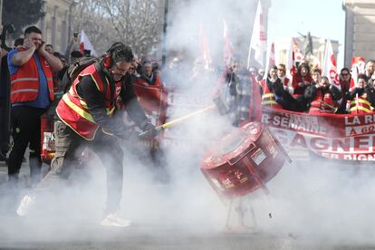 Un manifestante golpea un bote para hacer ruido mientras la gente participa en una manifestación contra la reforma del sistema de pensiones planificada por el gobierno francés, en Montpellier.