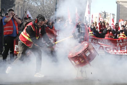 Un manifestante golpea un bote para hacer ruido mientras la gente participa en una manifestación contra la reforma del sistema de pensiones planificada por el gobierno francés, en Montpellier.