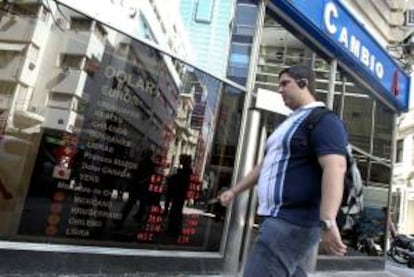 Un hombre pasa frente a una casa de cambio que muestra los valores de las divisas en el centro de Buenos Aires (Argentina). EFE/Archivo