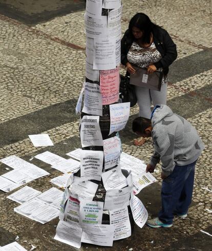 Dos personas leen ofertas de trabajo en una de las principales calles de São Paulo (Brasil)