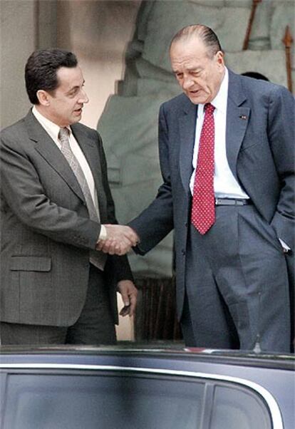 Jacques Chirac (derecha) saluda a Nicolas Sarkozy en París.
