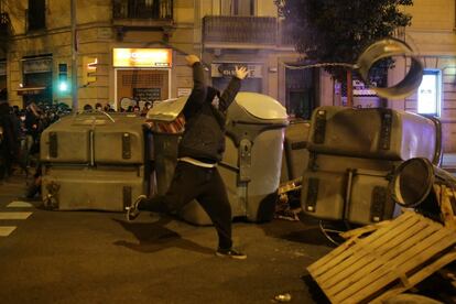 Un manifestante tira un elemento del moviliario urbano, durante las protestas de este jueves en Barcelona.