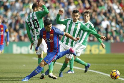 Luis Suárez, del Barcelona. trata de marcharse de varios defensas del Betis.