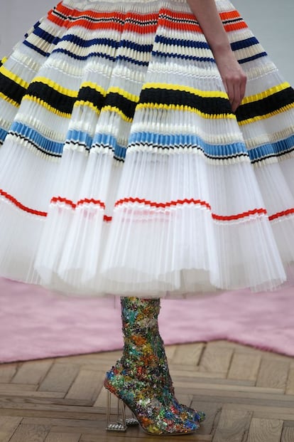 Una modelo lleva un vestido plisado y botas de lentejuelas multicolores, durante el ensayo con Raf Simons.