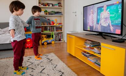 Dos hermanos siguen una clase de yoga infantil por televisión durante su confinamiento en su casa de Skopje, Macedonia, el 26 de marzo de 2020. 