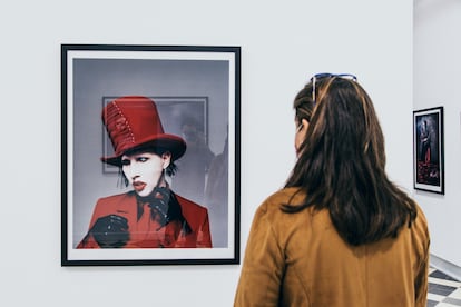 Una mujer observa uno de los retratos de Marilyn Manson en la exposición '21 años en el infierno' en La Térmica, en Málaga.