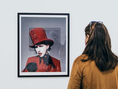 Una mujer observa uno de los retratos de Marilyn Manson en la exposición '21 años en el infierno' en La Térmica, en Málaga.