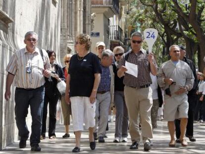 Un grupo de cruceristas junto al guía turístico ayer junto a la Lonja de Valencia.
