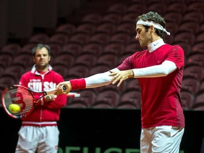 Federer, entrenándose hoy ante la mirada de Luthi, seleccionador suizo. 