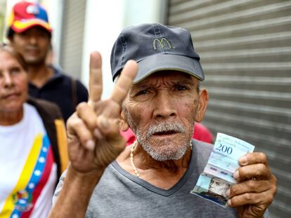 Un hombre muestra un billete de 200 bolívares, en Carcas, en una foto de febrero de 2019.