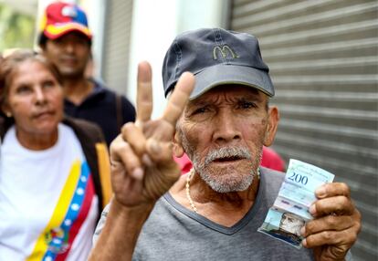 Un hombre muestra un billete de 200 bolívares, en Carcas, en una foto de febrero de 2019.