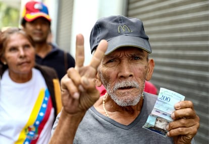 Un hombre muestra un billete de 200 bolívares, en Carcas, en una foto de febrero de 2019.