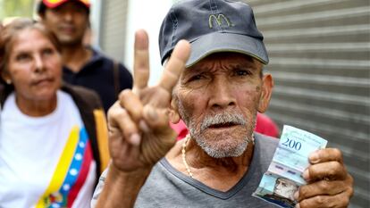 Un hombre muestra un billete de 200 bolívares, en Carcas, en una foto de febrero de 2019.