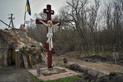 Señal de peligro de minas junto a un crucifijo en un control militar a la entrada de la localidad de Shevchenkove (región de Járkov).