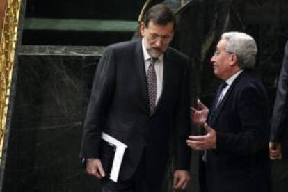 El presidente del Gobierno, Mariano Rajoy (i), conversa con el diputado popular Juan Carlos Aparicio, durante un pleno del Congreso. EFE/Archivo