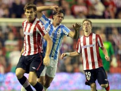 Llorente se anticipa a Demichelis con Muniain al fondo.