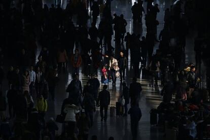 Una mujer empuja una maleta con su hija ayer en la estación Hongqiao de Shanghái.