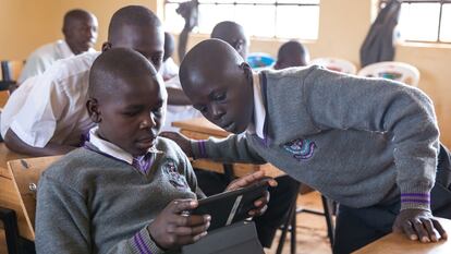 Un grupo de estudiantes interactúan con un tutor de IA en un aula en Nairobi, Kenia.
