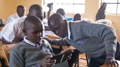 Un grupo de estudiantes interactúan con un tutor de IA en un aula en Nairobi, Kenia.