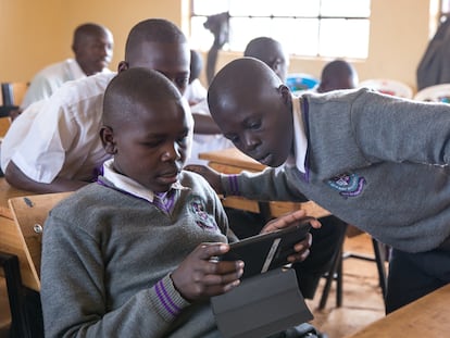 Un grupo de estudiantes interactúan con un tutor de IA en un aula en Nairobi, Kenia.