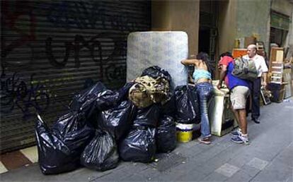 Bolsas de basura, un colchón y muebles, en un tramo de la calle de Sant Pau.