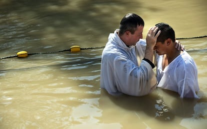 Un sacerdote bautiza a un peregrino cristiano en el llamado lugar del bautismo de Jesús en el valle del río Jordán de Cisjordania.