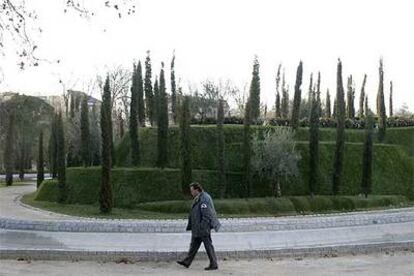 Un vigilante pasa delante del Bosque de los Ausentes, el jardín del parque del Retiro que recuerda a las 191 víctimas.