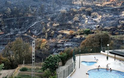 La vida vuelve a la normalidad. Imagen de la piscina del pueblo El Oro, con el monte quemado al fondo.