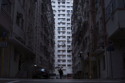 Un hombre camina frente a un edificio residencial y comercial donde se localizan los hogares ataúd, en Hong Kong.
