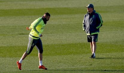 Benzema corre frente a Ben&iacute;tez, que supervisa el entrenamiento del Madrid, ayer en Valdebebas.