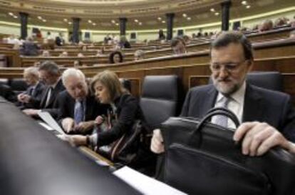 El presidente del Gobierno, Mariano Rajoy, junto a la vicepresidenta, Soraya S&aacute;enz de Santamar&iacute;a y el ministro de Asuntos Exteriores, Jos&eacute; Manuel Garc&iacute;a-Margallo, al inicio hoy del pleno del Congreso de los Diputados. 