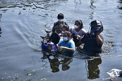 El fuerte viento y el agua caída durante varios días seguidos han causado inundaciones y deslaves. En la imagen, una familia camina por una calle inundada en Villahermosa, en el estado de Tabasco, México.