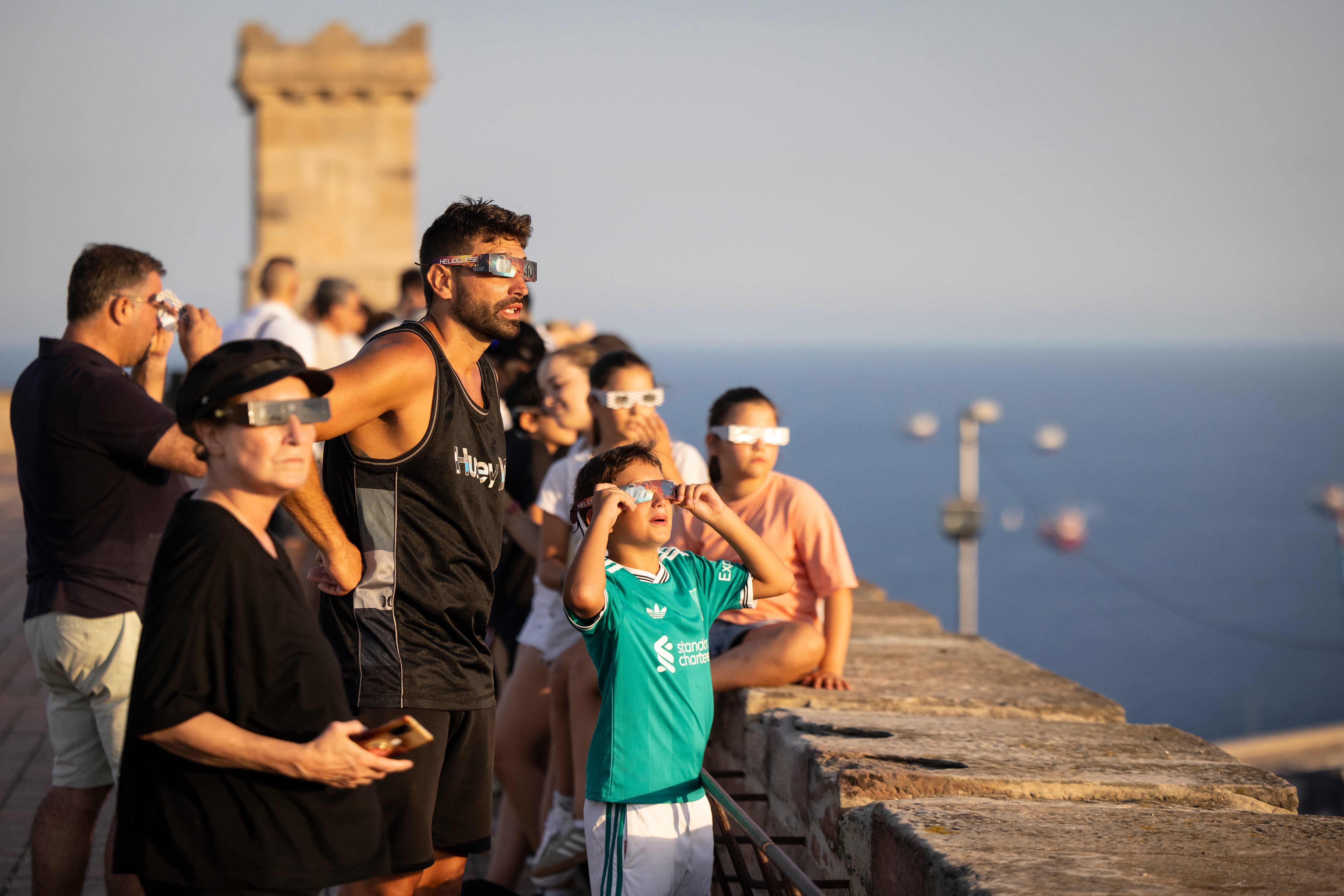 Gente viendo el eclipse el 12 de agosto desde el Castillo de Montjuic de Barcelona.