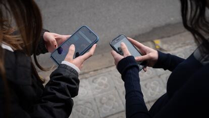 Dos personas utilizan teléfonos móviles en Barcelona, ​​Cataluña, España.