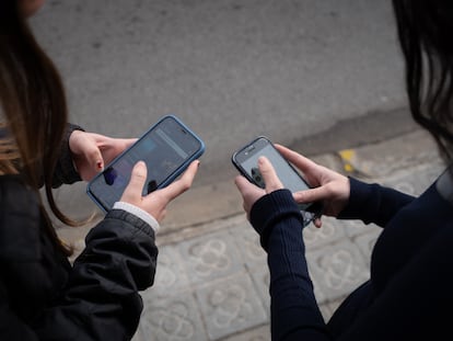 Dos personas utilizan teléfonos móviles en Barcelona, ​​Cataluña, España.