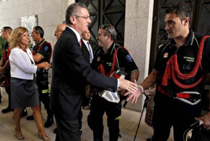 El alcalde Alberto Ruiz-Gallardón saluda a miembros del cuerpo de bomberos de Madrid acompañado de Ana Botella, responsable de Medio Ambiente y Movilidad del Ayuntamiento de la capital.