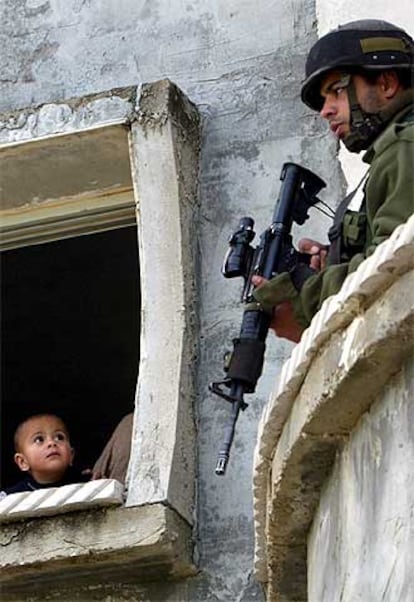 Un niño palestino mira a un soldado israelí en Beta (Cisjordania).