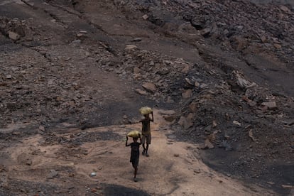 Unos trabajadores llevan sacos de carbón de una mina a cielo abierto, el 30 de agosto en Dhanbad, India.