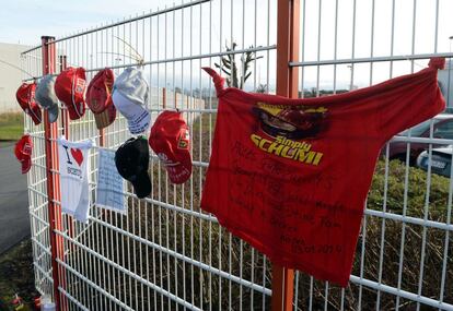 Camisetas y gorras con mensajes de ánimo para Schumacher cuelgan de una valla en el Hospital de Grenoble