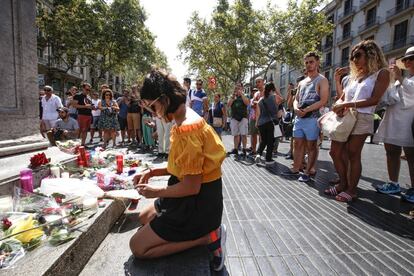 Una joven observa un altar improvisado en Las Ramblas de Barcelona.