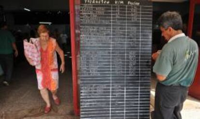 Un hombre observa una tabla de precios en un mercado estatal, en La Habana (Cuba).