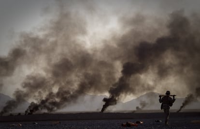 9 de junio de 2011. Un infante de marina estadounidense recoge los suministros que han sido distribuidos a través de pequeños paracaídas desde un avión fuera de la base de operaciones Edi, en la provincia de Helmand, en el sur de Afganistan.