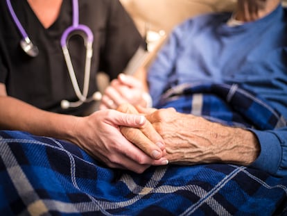Una enfermera cuida a un hombre en una residencia de ancianos.