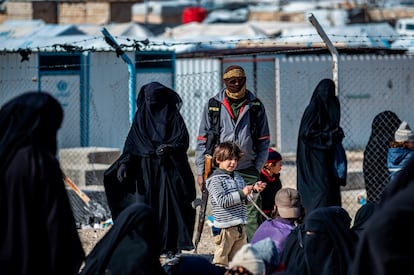 Un kurdo vigila a mujeres y sus hijos en el campo de Al Hol, en Siria, el pasado enero. 