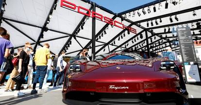 Gente observando un Porsche Taycan expuesto en la ciudad de Múnich.