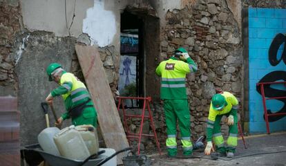 Tres operarios tapian las entradas del edificio que albergaba el Ateneu Popular de Sarrià.
 
 
 
 