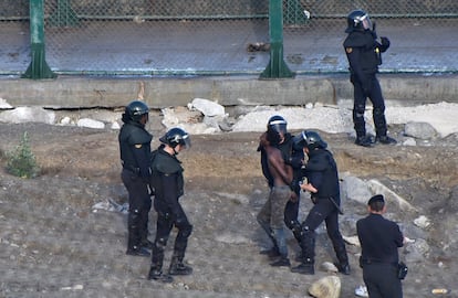 En el salto de 2018 lograron entrar en España 602 personas, de un grupo de 850 que había intentado la acción. El enfrentamiento dejó 132 heridos y 22 guardias con contusiones, quemaduras y problemas respiratorios. En la imagen, uno de los inmigrantes encaramados a la valla es conducido a la frontera con Marruecos.